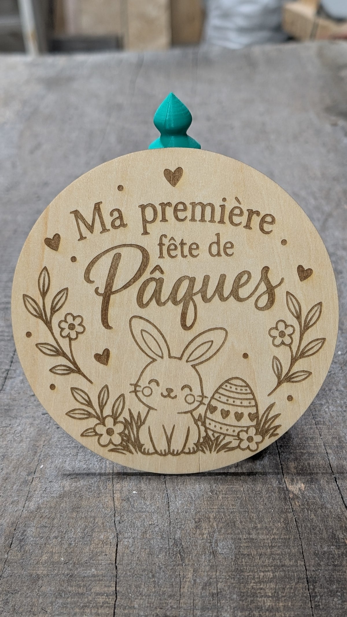 Pastille en bois gravé « Ma première fête de Pâques », avec lapin, œufs et fleurs.