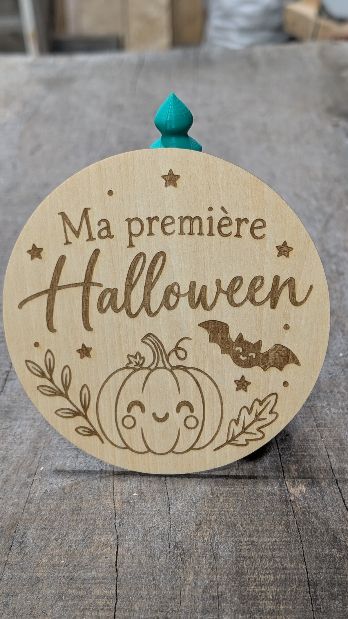 Pastille en bois gravé « Ma première Halloween », avec citrouille, chauve-souris et feuillage.