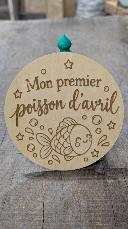 Pastille en bois gravé « Mon premier poisson d’avril », avec poisson, bulles et étoiles.