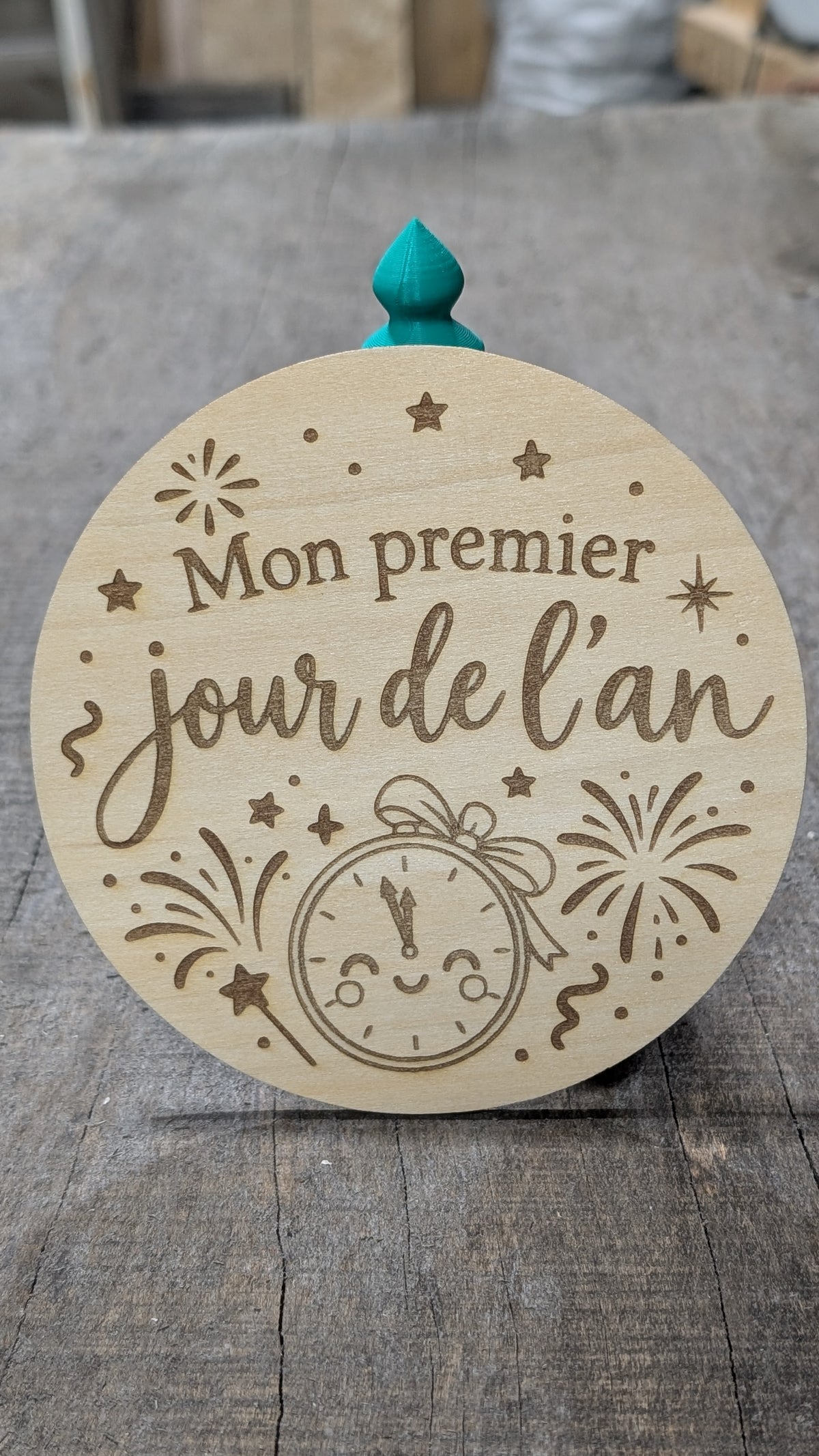 Pastille en bois gravé « Mon premier jour de l’an », avec horloge et feux d’artifice.